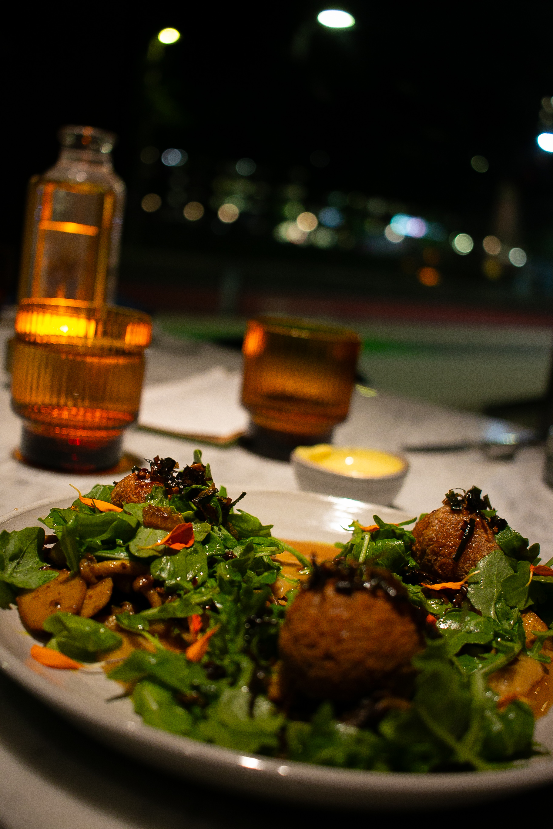 The Sindhi Mushroom plate over dressed greens with edible flowers at AMA
