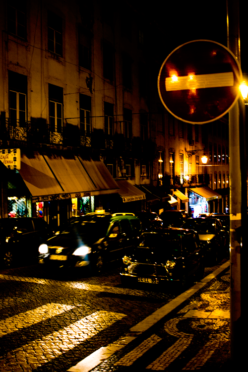 Coisa Mais Linda 1950s Bossa - Atmospheric nighttime street scene in Lisbon with golden lighting, cobblestones, and classic cars
