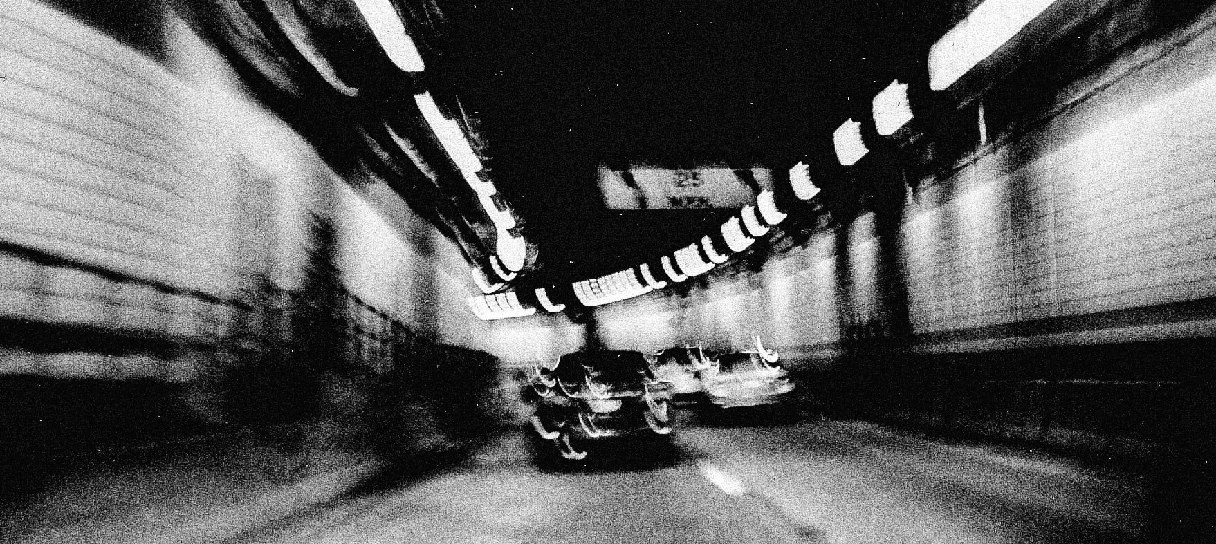 On the Highway of Life - Artistic black and white photograph taken from inside a tunnel looking out at a highway in Boston