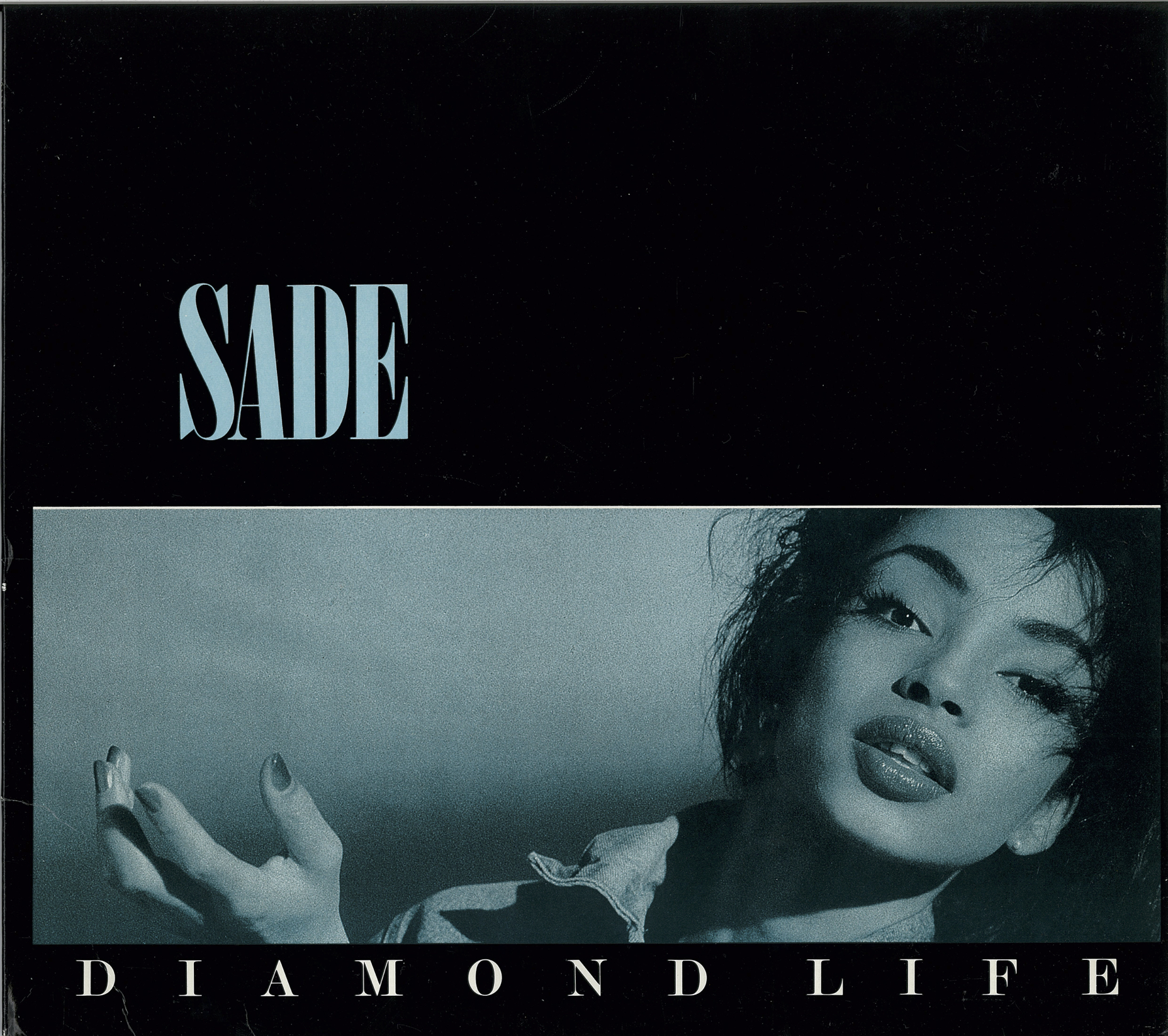 Iconic album cover of Sade's Diamond Life featuring Helen Folasade Adu in an elegant black and white photograph, with 'SADE' in large white letters at top and 'DIAMOND LIFE' at bottom
